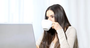 Νέα γυναίκα με τον υπολογιστή και το φλυτζάνι υπό εξέταση στοκ φωτογραφίες Νέα γυναίκα με τον υπολογιστή και το φλυτζάνι υπό εξέταση στοκ φωτογραφίες