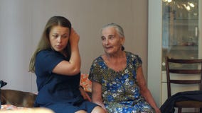 Νέα γυναίκα που αγκαλιάζει τη γιαγιά ενενηντάχρονων της Νέα γυναίκα που αγκαλιάζει τη γιαγιά ενενηντάχρονων της