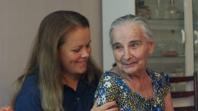 Νέα γυναίκα που αγκαλιάζει τη γιαγιά ενενηντάχρονων της Νέα γυναίκα που αγκαλιάζει τη γιαγιά ενενηντάχρονων της