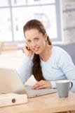 Νέα γυναίκα που εργάζεται στο lap-top στο φωτεινό γραφείο στοκ εικόνες με δικαίωμα ελεύθερης χρήσης Νέα γυναίκα που εργάζεται στο lap-top στο φωτεινό γραφείο στοκ εικόνες με δικαίωμα ελεύθερης χρήσης