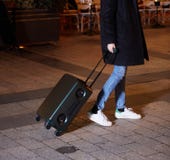 Νέα γυναίκα που περπατά γύρω από την πόλη Το χέρι της κρατά τις αποσκευές στοκ φωτογραφίες με δικαίωμα ελεύθερης χρήσης Νέα γυναίκα που περπατά γύρω από την πόλη Το χέρι της κρατά τις αποσκευές στοκ φωτογραφίες με δικαίωμα ελεύθερης χρήσης