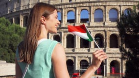 Νέα γυναίκα που στέκεται κοντά σε Colosseum στη Ρώμη, Ιταλία Έφηβη που κυματίζει την ιταλική σημαία σε σε αργή κίνηση Νέα γυναίκα που στέκεται κοντά σε Colosseum στη Ρώμη, Ιταλία Έφηβη που κυματίζει την ιταλική σημαία σε σε αργή κίνηση