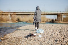 Νέα γυναίκα που συλλέγει τα πλαστικά απορρίμματα από την παραλία και που βάζει τα στις μαύρες πλαστικές τσάντες για ανακύκλωσης Κ στοκ εικόνα με δικαίωμα ελεύθερης χρήσης Νέα γυναίκα που συλλέγει τα πλαστικά απορρίμματα από την παραλία και που βάζει τα στις μαύρες πλαστικές τσάντες για ανακύκλωσης Κ στοκ εικόνα με δικαίωμα ελεύθερης χρήσης