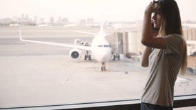 Νέα Ευρωπαία γυναίκα που μιλά στο τηλέφωνο κοντά στο τελικό παράθυρο αερολιμένων που ανατρέπεται και που ματαιώνεται μετά από να απόθεμα βίντεο Νέα Ευρωπαία γυναίκα που μιλά στο τηλέφωνο κοντά στο τελικό παράθυρο αερολιμένων που ανατρέπεται και που ματαιώνεται μετά από να απόθεμα βίντεο