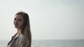 Νέα ευτυχής γυναίκα με μακρυμάλλη σε μια μπεζ κινηματογράφηση σε πρώτο πλάνο παλτών που χορεύει στην παραλία θάλασσας απόθεμα βίντεο Νέα ευτυχής γυναίκα με μακρυμάλλη σε μια μπεζ κινηματογράφηση σε πρώτο πλάνο παλτών που χορεύει στην παραλία θάλασσας απόθεμα βίντεο
