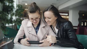 Νέα κόρη μητέρων και εφήβων που εξετάζει το smartphone σε αναμονή για μια δι φιλμ μικρού μήκους Νέα κόρη μητέρων και εφήβων που εξετάζει το smartphone σε αναμονή για μια δι φιλμ μικρού μήκους