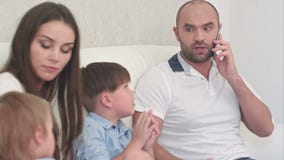 Νέα μητέρα που είναιη με το σύζυγό της που μιλά στο τηλέφωνο και που δεν παίζει με τους γιους του απόθεμα βίντεο Νέα μητέρα που είναιη με το σύζυγό της που μιλά στο τηλέφωνο και που δεν παίζει με τους γιους του απόθεμα βίντεο