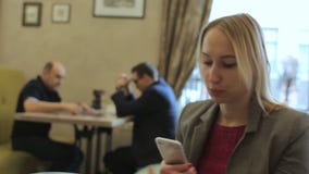 Νέα μοντέρνη ξανθή γυναίκα που παίρνει selfie τη φωτογραφία με το κινητό τηλέφωνο στον καφέ απόθεμα βίντεο Νέα μοντέρνη ξανθή γυναίκα που παίρνει selfie τη φωτογραφία με το κινητό τηλέφωνο στον καφέ απόθεμα βίντεο