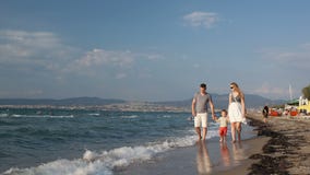 Νέα οικογένεια που περπατά στην παραλία φιλμ μικρού μήκους Νέα οικογένεια που περπατά στην παραλία φιλμ μικρού μήκους