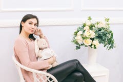 Νέα συνεδρίαση γυναικών στην ψάθινη καρέκλα στο σπίτι στοκ φωτογραφία Νέα συνεδρίαση γυναικών στην ψάθινη καρέκλα στο σπίτι στοκ φωτογραφία