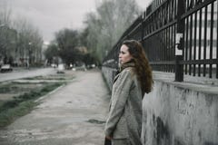 Νέα τοποθέτηση γυναικών στην οδό σε μια καφετιά ζακέτα στοκ εικόνες Νέα τοποθέτηση γυναικών στην οδό σε μια καφετιά ζακέτα στοκ εικόνες