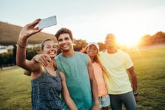 Νέα φίλαθλη γυναίκα που παίρνει ένα selfie με τους φίλους στοκ εικόνα Νέα φίλαθλη γυναίκα που παίρνει ένα selfie με τους φίλους στοκ εικόνα