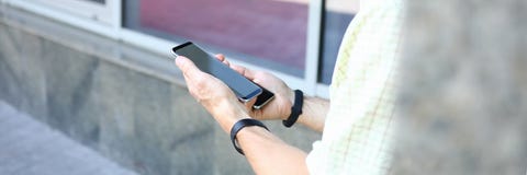 Νέα όμορφη αρσενική εκμετάλλευση δύο σύγχρονα smartphones στα χέρια στοκ εικόνα με δικαίωμα ελεύθερης χρήσης Νέα όμορφη αρσενική εκμετάλλευση δύο σύγχρονα smartphones στα χέρια στοκ εικόνα με δικαίωμα ελεύθερης χρήσης
