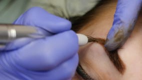 Νέα όμορφη γυναίκα που παίρνει τη δερματοστιξία φρυδιών μόνιμο makeup για τα φρύδια στο σαλόνι ομορφιάς κίνηση αργή απόθεμα βίντεο Νέα όμορφη γυναίκα που παίρνει τη δερματοστιξία φρυδιών μόνιμο makeup για τα φρύδια στο σαλόνι ομορφιάς κίνηση αργή απόθεμα βίντεο