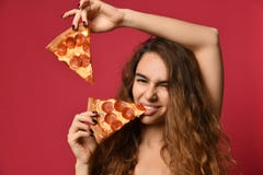 Νέα όμορφη γυναίκα που τρώει τη φέτα pepperoni της πίτσας στο ρόδινο κόκκινο στοκ εικόνες Νέα όμορφη γυναίκα που τρώει τη φέτα pepperoni της πίτσας στο ρόδινο κόκκινο στοκ εικόνες