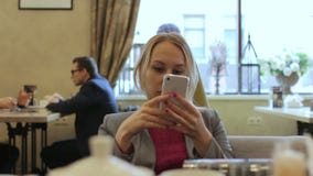 Νέες ειδήσεις ανάγνωσης επιχειρηματιών με το smartphone, εργαζόμενος στον καφέ, χαμόγελο απόθεμα βίντεο Νέες ειδήσεις ανάγνωσης επιχειρηματιών με το smartphone, εργαζόμενος στον καφέ, χαμόγελο απόθεμα βίντεο