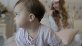 Νέες μητέρα και κόρη το πρωί του νέου έτους στο κρεβάτι στο σπίτι απόθεμα βίντεο Νέες μητέρα και κόρη το πρωί του νέου έτους στο κρεβάτι στο σπίτι απόθεμα βίντεο