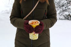 Νέο popcorn εκμετάλλευσης γυναικών το χειμώνα, στα γάντια στοκ εικόνα Νέο popcorn εκμετάλλευσης γυναικών το χειμώνα, στα γάντια στοκ εικόνα