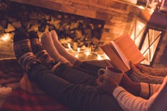 Νέο ζεύγος κοντά στο βιβλίο χειμερινής ανάγνωσης εστιών στο σπίτι και το κακάο κατανάλωσης στοκ φωτογραφίες με δικαίωμα ελεύθερης χρήσης Νέο ζεύγος κοντά στο βιβλίο χειμερινής ανάγνωσης εστιών στο σπίτι και το κακάο κατανάλωσης στοκ φωτογραφίες με δικαίωμα ελεύθερης χρήσης