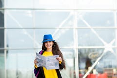 Νέο κορίτσι με ένα σακίδιο πλάτης πίσω από τον ώμο της που κρατά έναν χάρτη, στην οδό κοντά στον αερολιμένα στοκ φωτογραφία με δικαίωμα ελεύθερης χρήσης Νέο κορίτσι με ένα σακίδιο πλάτης πίσω από τον ώμο της που κρατά έναν χάρτη, στην οδό κοντά στον αερολιμένα στοκ φωτογραφία με δικαίωμα ελεύθερης χρήσης