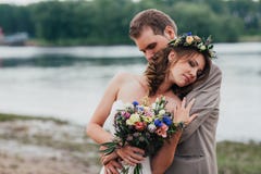 Νέο μόνιμο αγκάλιασμα νεόνυμφων και νυφών στο υπόβαθρο του ποταμού Στοκ Φωτογραφία Νέο μόνιμο αγκάλιασμα νεόνυμφων και νυφών στο υπόβαθρο του ποταμού Στοκ Φωτογραφία