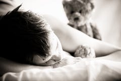 Νέο να βρεθεί αγοριών στο κρεβάτι με Teddy αντέχει στοκ φωτογραφία με δικαίωμα ελεύθερης χρήσης Νέο να βρεθεί αγοριών στο κρεβάτι με Teddy αντέχει στοκ φωτογραφία με δικαίωμα ελεύθερης χρήσης