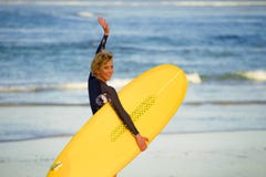 Νέο όμορφο και ευτυχές κορίτσι surfer που περπατά προς τη θάλασσα που φέρνει τον κίτρινο πίνακα κυματωγών έτοιμο για το εύθυμο en στοκ φωτογραφίες Νέο όμορφο και ευτυχές κορίτσι surfer που περπατά προς τη θάλασσα που φέρνει τον κίτρινο πίνακα κυματωγών έτοιμο για το εύθυμο en στοκ φωτογραφίες