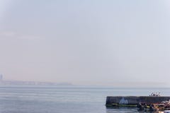 Νέοι στην αποβάθρα στο υπόβαθρο της θάλασσας στοκ εικόνα με δικαίωμα ελεύθερης χρήσης Νέοι στην αποβάθρα στο υπόβαθρο της θάλασσας στοκ εικόνα με δικαίωμα ελεύθερης χρήσης