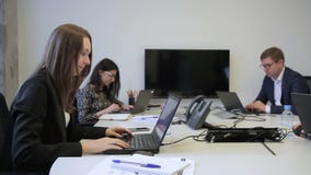 Νέοι υπάλληλοι που εργάζονται στο γραφείο με τα lap-top που κάθονται στην επιχείρηση απόθεμα βίντεο Νέοι υπάλληλοι που εργάζονται στο γραφείο με τα lap-top που κάθονται στην επιχείρηση απόθεμα βίντεο