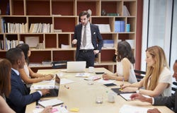 Νέος αρσενικός διευθυντής που στέκεται σε μια συνεδρίαση των επιχειρησιακών αιθουσών συνεδριάσεων στοκ εικόνες με δικαίωμα ελεύθερης χρήσης Νέος αρσενικός διευθυντής που στέκεται σε μια συνεδρίαση των επιχειρησιακών αιθουσών συνεδριάσεων στοκ εικόνες με δικαίωμα ελεύθερης χρήσης