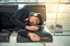 Νέος ασιατικός ύπνος ατόμων στον πάγκο στο τερματικό αερολιμένων στοκ εικόνα με δικαίωμα ελεύθερης χρήσης Νέος ασιατικός ύπνος ατόμων στον πάγκο στο τερματικό αερολιμένων στοκ εικόνα με δικαίωμα ελεύθερης χρήσης