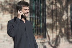 Νέος αστικός επιχειρηματίας στο έξυπνο τηλέφωνο στην οδό που μιλά σε smar στοκ φωτογραφία Νέος αστικός επιχειρηματίας στο έξυπνο τηλέφωνο στην οδό που μιλά σε smar στοκ φωτογραφία