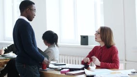Νέος αφρικανικός άνδρας εργαζομένων γραφείων που μιλά στην όμορφη μέση ηλικίας καυκάσια κύρια γυναίκα στον υγιή mutiethnic εργασι απόθεμα βίντεο Νέος αφρικανικός άνδρας εργαζομένων γραφείων που μιλά στην όμορφη μέση ηλικίας καυκάσια κύρια γυναίκα στον υγιή mutiethnic εργασι απόθεμα βίντεο