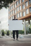 Νέος ελκυστικός κενός καμβάς εκμετάλλευσης ατόμων και εξέταση το θεατή Μπροστινή όψη στοκ εικόνα Νέος ελκυστικός κενός καμβάς εκμετάλλευσης ατόμων και εξέταση το θεατή Μπροστινή όψη στοκ εικόνα