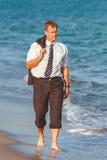 Νέος επιχειρηματίας που περπατά στην παραλία θορίου ε μετά από το χρόνο εργασίας Στοκ Φωτογραφία Νέος επιχειρηματίας που περπατά στην παραλία θορίου ε μετά από το χρόνο εργασίας Στοκ Φωτογραφία
