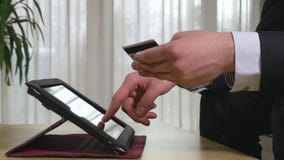 Νέος επιχειρηματίας που χρησιμοποιεί τις σε απευθείας σύνδεση τραπεζικές εργασίες σε ένα PC ταμπλετών απόθεμα βίντεο Νέος επιχειρηματίας που χρησιμοποιεί τις σε απευθείας σύνδεση τραπεζικές εργασίες σε ένα PC ταμπλετών απόθεμα βίντεο