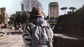 Νέος περιστασιακός χαλαρωμένος θηλυκός τουρίστας με το σακίδιο πλάτης στα μοντέρνα ενδύματα που περπατά στο φόρουμ της Ρώμης που φιλμ μικρού μήκους Νέος περιστασιακός χαλαρωμένος θηλυκός τουρίστας με το σακίδιο πλάτης στα μοντέρνα ενδύματα που περπατά στο φόρουμ της Ρώμης που φιλμ μικρού μήκους