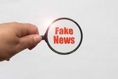 Να ενισχύσει - γυαλί υπό εξέταση και μια πλαστή λέξη ειδήσεων στο άσπρο υπόβαθρο στοκ εικόνες Να ενισχύσει - γυαλί υπό εξέταση και μια πλαστή λέξη ειδήσεων στο άσπρο υπόβαθρο στοκ εικόνες