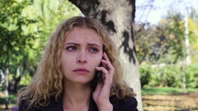 Να φωνάξει κοριτσιών που μιλά στην τηλεφωνική συνεδρίαση σε έναν πάγκο στο πάρκο απόθεμα βίντεο Να φωνάξει κοριτσιών που μιλά στην τηλεφωνική συνεδρίαση σε έναν πάγκο στο πάρκο απόθεμα βίντεο