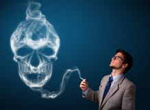 Νεαρός άνδρας που καπνίζει το επικίνδυνο τσιγάρο με τον τοξικό καπνό κρανίων Στοκ Εικόνα Νεαρός άνδρας που καπνίζει το επικίνδυνο τσιγάρο με τον τοξικό καπνό κρανίων Στοκ Εικόνα