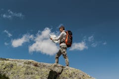 Νεαρός άνδρας με το μεγάλο σακίδιο πλάτης που περπατά για να φθάσει στην κορυφή του βουνού κατά τη διάρκεια μιας ηλιόλουστης ημέρ στοκ εικόνα Νεαρός άνδρας με το μεγάλο σακίδιο πλάτης που περπατά για να φθάσει στην κορυφή του βουνού κατά τη διάρκεια μιας ηλιόλουστης ημέρ στοκ εικόνα