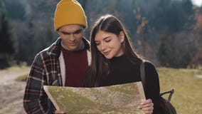 Νεολαίες που χαμογελούν το ευτυχές ζεύγος που στέκεται στα βουνά Αυτοί που απολαμβάνουν την πεζοπορία τους Κοίταγμα στο χάρτη του φιλμ μικρού μήκους Νεολαίες που χαμογελούν το ευτυχές ζεύγος που στέκεται στα βουνά Αυτοί που απολαμβάνουν την πεζοπορία τους Κοίταγμα στο χάρτη του φιλμ μικρού μήκους