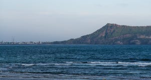 ΝΗΣΊ JEJU, ΚΟΡΈΑ: Άποψη του ηφαιστειακού κώνου Seongsan Ilchulbong από την πόλη στο λόφο στοκ εικόνα ΝΗΣΊ JEJU, ΚΟΡΈΑ: Άποψη του ηφαιστειακού κώνου Seongsan Ilchulbong από την πόλη στο λόφο στοκ εικόνα
