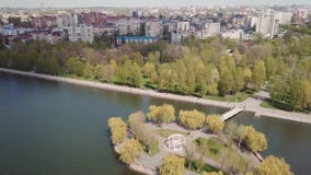Νησί στη λίμνη στο πάρκο κατά την πόλης άποψη από τον κηφήνα φιλμ μικρού μήκους Νησί στη λίμνη στο πάρκο κατά την πόλης άποψη από τον κηφήνα φιλμ μικρού μήκους