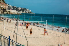 ΝΙΚΑΙΑ, ΓΑΛΛΙΑ - 26 ΙΟΥΝΊΟΥ 2017: Άνθρωποι που απολαμβάνουν τον ηλιόλουστο καιρό στην παραλία πετρών και που παίζουν την πετοσφαί στοκ εικόνες με δικαίωμα ελεύθερης χρήσης ΝΙΚΑΙΑ, ΓΑΛΛΙΑ - 26 ΙΟΥΝΊΟΥ 2017: Άνθρωποι που απολαμβάνουν τον ηλιόλουστο καιρό στην παραλία πετρών και που παίζουν την πετοσφαί στοκ εικόνες με δικαίωμα ελεύθερης χρήσης