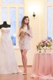 Νύφη σε ένα peignoir που στέκεται δίπλα στο γαμήλιο φόρεμά της στοκ φωτογραφία με δικαίωμα ελεύθερης χρήσης Νύφη σε ένα peignoir που στέκεται δίπλα στο γαμήλιο φόρεμά της στοκ φωτογραφία με δικαίωμα ελεύθερης χρήσης