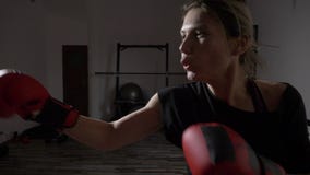 Ξανθό κορίτσι που χτυπά τη punching τσάντα νευρικά στη γυμναστική μετά από να χωρίσει με το φίλο της σε σε αργή κίνηση - απόθεμα βίντεο Ξανθό κορίτσι που χτυπά τη punching τσάντα νευρικά στη γυμναστική μετά από να χωρίσει με το φίλο της σε σε αργή κίνηση - απόθεμα βίντεο