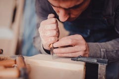 ξύλινη επεξεργασία Joinery εργασία Ξύλινη γλυπτική Ο ξυλουργός χρησιμοποιεί ένα τέμνον μαχαίρι για τη διαμόρφωση στοκ εικόνες ξύλινη επεξεργασία Joinery εργασία Ξύλινη γλυπτική Ο ξυλουργός χρησιμοποιεί ένα τέμνον μαχαίρι για τη διαμόρφωση στοκ εικόνες