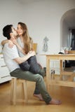 Ο άνδρας φιλά τη συνεδρίαση γυναικών στα πόδια του στην κουζίνα στοκ εικόνα με δικαίωμα ελεύθερης χρήσης Ο άνδρας φιλά τη συνεδρίαση γυναικών στα πόδια του στην κουζίνα στοκ εικόνα με δικαίωμα ελεύθερης χρήσης