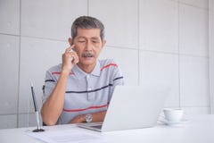 Ο ανώτερος επιχειρηματίας της Ασίας εξετάζει το lap-top και τη σκέψη στοκ εικόνες με δικαίωμα ελεύθερης χρήσης Ο ανώτερος επιχειρηματίας της Ασίας εξετάζει το lap-top και τη σκέψη στοκ εικόνες με δικαίωμα ελεύθερης χρήσης
